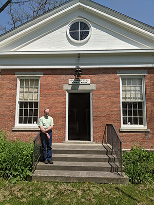 Charlotte Historical Society President Dan Cole on the front steps of The Charlotte Museum, at the intersection of Church Hill, Museum and Hinesburg Roads. Photo credit Matt Zucker