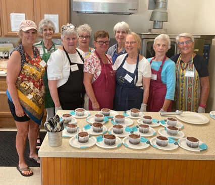 July 26 Monday Munch cooking team—Front row: Cindi Burns, Carol Strobeck, Sue Foley, Susan Hyde, Beth Merritt, Jane McCullough. Back row: Marjorie London, Judy Dugan, Ann Hansen. Photo by Lori York