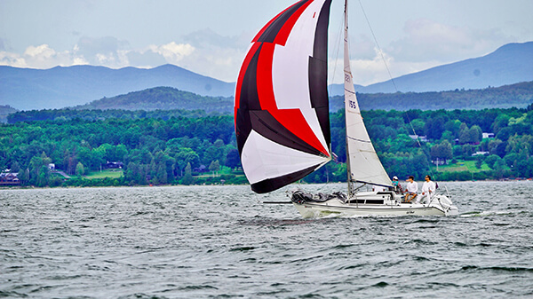 Lil’Bot, sailed by Benedek Erdos, heads downwind during the Diamond Island Regatta on Aug. 14. Lil’Bot, representing Diamond Island Yacht Club, finished first in the Spinnaker C Class in the DIR. — Photo by Joe Gannon