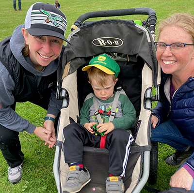 L to R: Maria Godleski, Eli, 2 1/2 and Eli’s mom, Liz Royer , wait for the Tractor Parade.