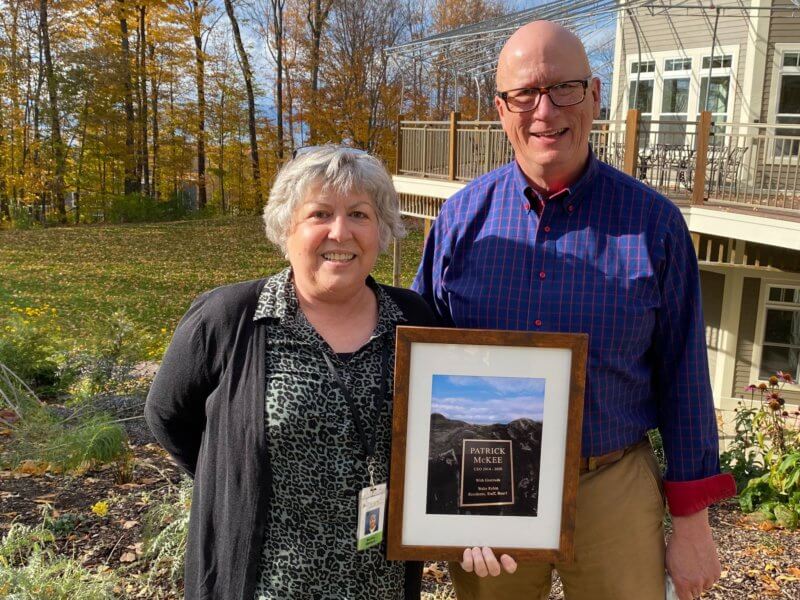 Martha Maksym, current CEO of Wake Robin, stands with her predecessor Patrick McKee, who was honored for his years of service to the community with the planting of a Dawn Redwood tree on the property’s lower meadow.