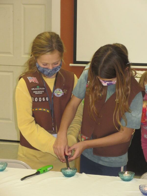 Colbie Curler and Kierstan LaClair lighting a candle as part of their bridging ceremony as they prepare to bridge from Brownie to Junior Scouts.