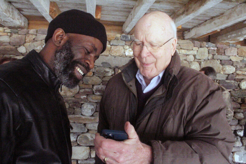 Photo by Scooter MacMillan Patrick Leahy shows pictures of his grandchildren to artist Julio Desmond.