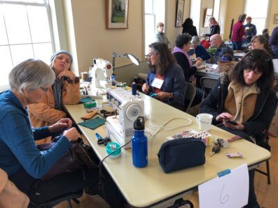 Photo contributed. Catherine Bock, left, sews and shows how to sew at a previous Repair Café.