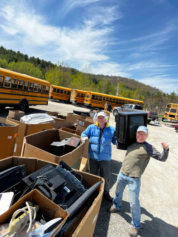 Courtesy photo From left, Wolfger Schneider and Jamey Gerlaugh collect e-waste during Green Up Day for Sustainable Charlotte, which sends the electronic waste to be recycled by a company in Middlebury.