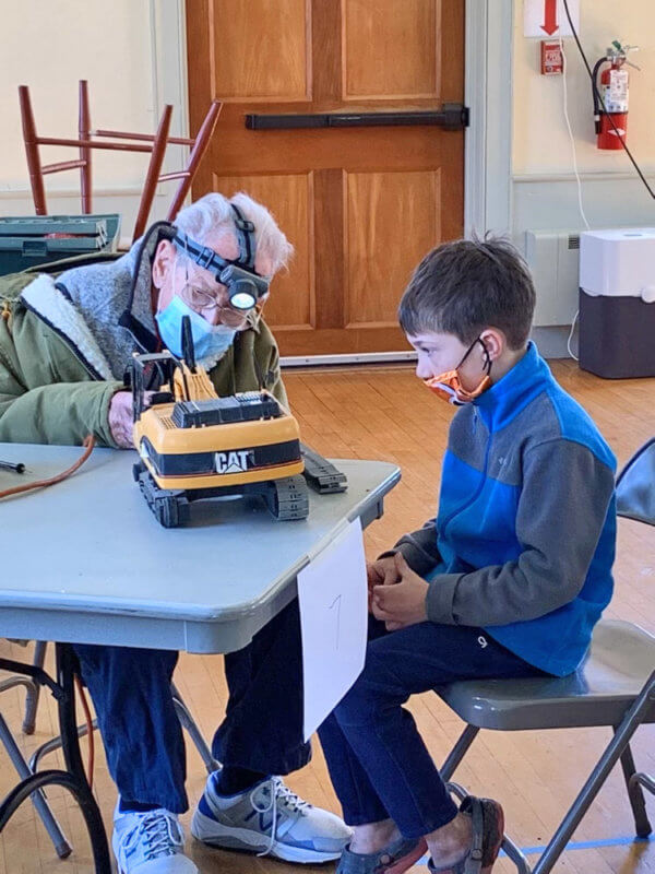 Photo by Mickey Davis Norton Davis, Repair Café fixer works on Eddie Moore’s toy.