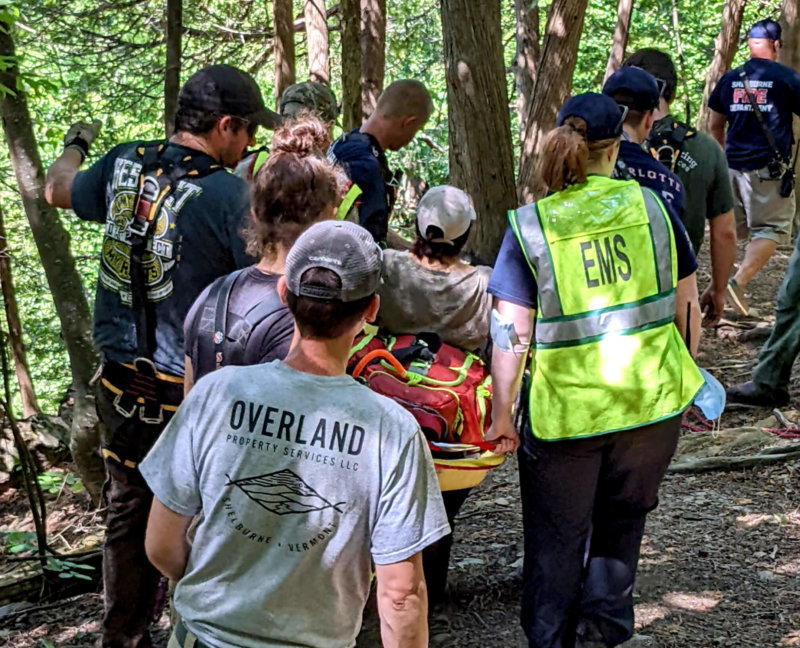 Photo by Lee Krohn At least 18 responders helped evacuate a 70-year-old woman who fell and injured her leg hiking on Mt. Philo shortly before 1:30 p.m. on Monday, June 13. Charlotte Fire and Rescue chief Dick St. George said the woman was hiking on the Devil’s Chair Trail, the oldest trail on the mountain and the trickiest to evacuate someone from. Besides Charlotte, responders came from Ferrisburgh, Shelburne and the park ranger. Getting the injured woman to the ambulance took almost two hours and extensive rope, rigging equipment and complicated belays, St. George said, ‘We never would have gotten her out without the mutual aid manpower.’