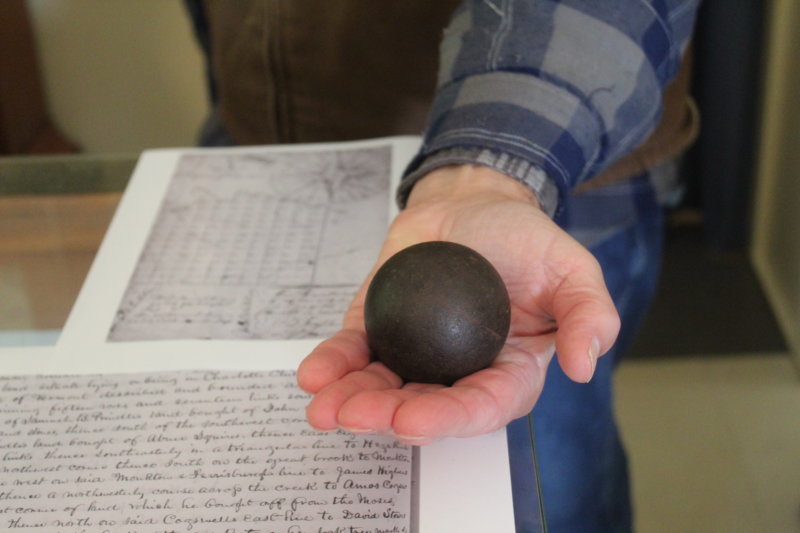 Photo by Scooter MacMillan. Dan Cole holds a cannon ball that was shot at members of the McNeil family and others who had taunted British boats going to south on Lake Champlain to fight in the War of 1812.