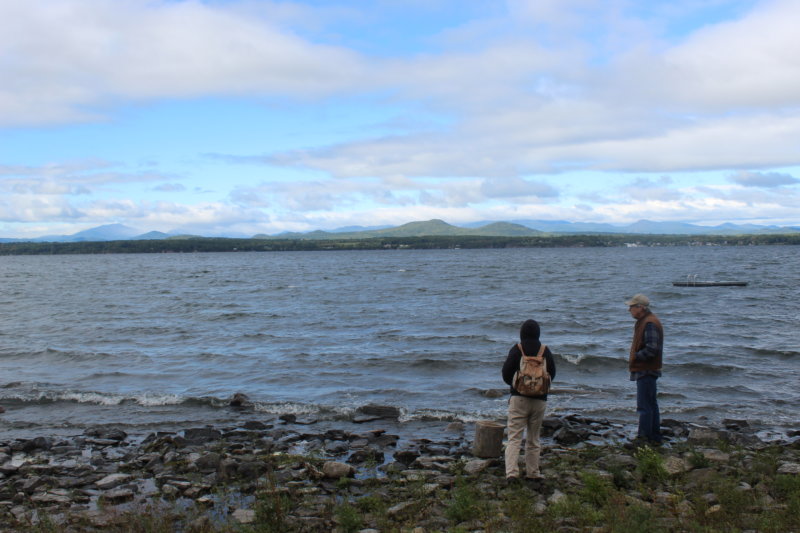 Photo by Scooter MacMillan. From left, Molly King and Dan Cole, both of the Charlotte Historical Society, look out over Lake Champlain at the spot where McNeil’s Ferry once operated.