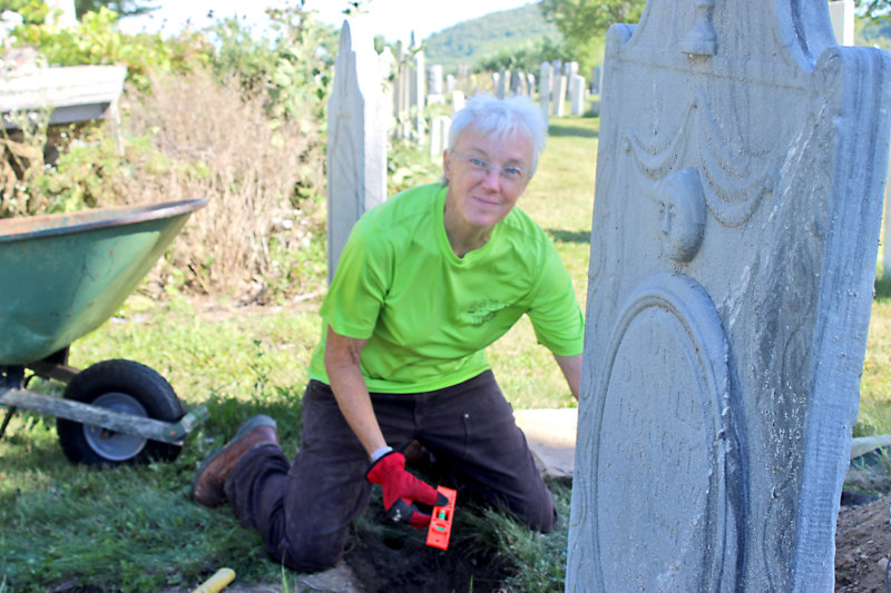 Photo by Scooter MacMillan Diane Leary levels and plumbs gravestones in Charlotte’s Barber Cemetery.