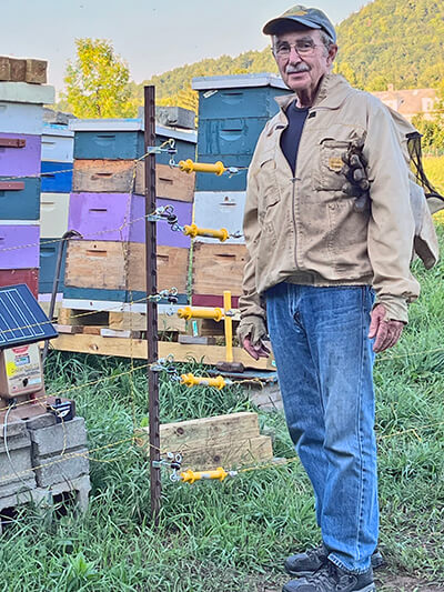 Photo by Connie Haven. Bob Haven hanging with his hives.