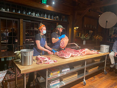 Photo by Scooter MacMillanHannah Clark and Mike Kirk work through the process of cutting a hog down into its primal parts.