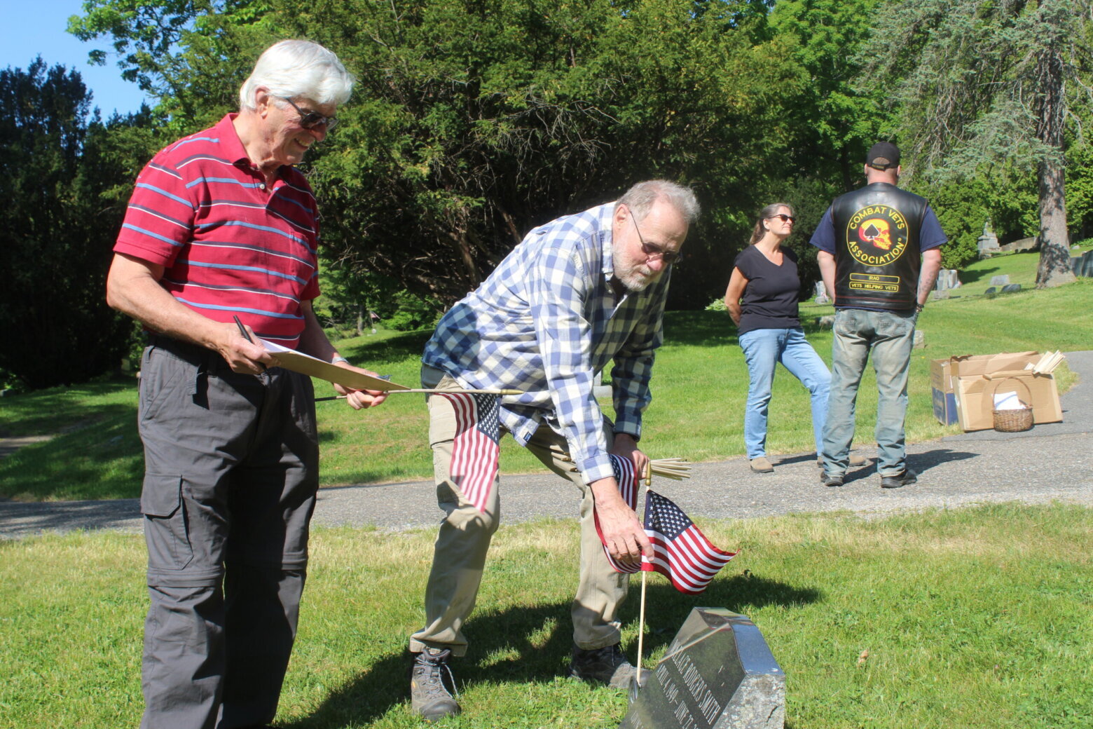 After the ceremony, people pitched in to replace the flags on veterans’ graves with new ones.