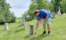 Courtesy photo Stewart Robinson places a flag during the Grange’s Memorial Day efforts.