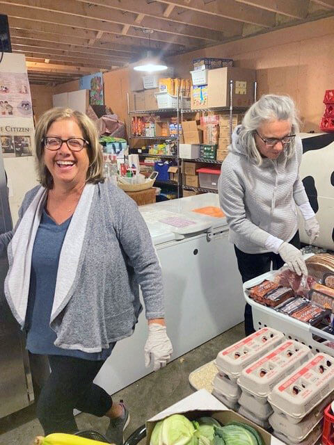 Marie Blanchette (left) and Kim Ziegelmen work on organizing the Charlotte Food Shelf.