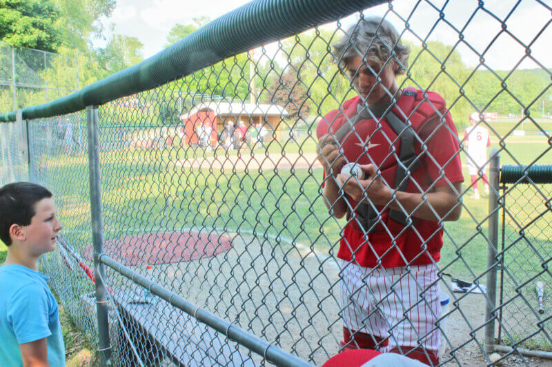 Asa Roberts signs a ball for a young fan. As the Red Hawks progressed in the state playoff, younger audience members began asking CVU players for their autographs. Assistant coach Sam Fontaine said this is a newer tradition the coaches have endorsed, seeing it as a way to give back to the community and for players to be role models for future Redhawks.