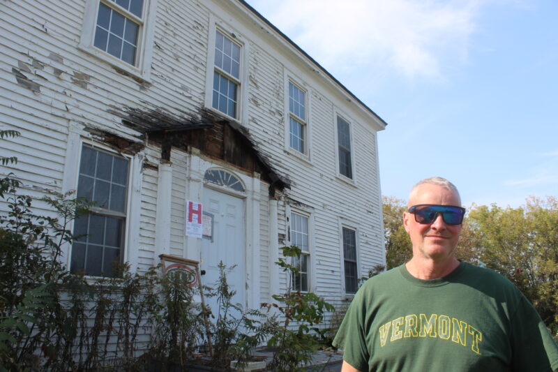 Photo by Scooter MacMillan.
Jon Maguire stands in front of the building usually referred to as the Sheehan house, which he is renovating into a restaurant in East Charlotte.