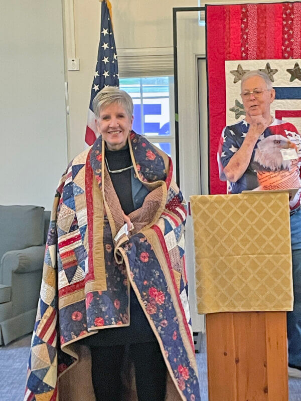 Photo by Lori York Veteran Lin Kalson receives a Quilt of Valor in a dedication ceremony performed by André Emmel.