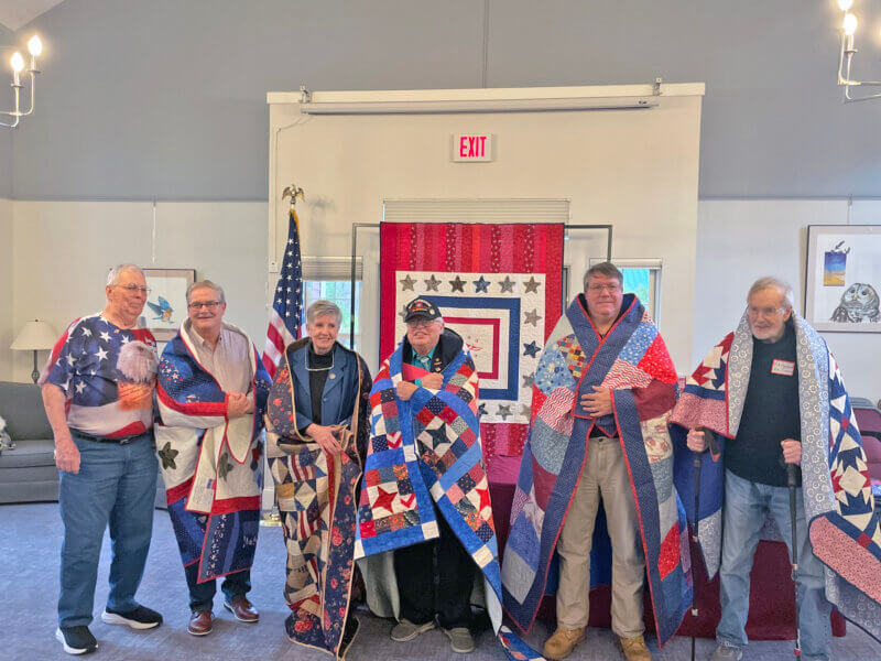 Photo by Lori York. Veterans wrapped in their Quilts of Valor for the dedication ceremony.