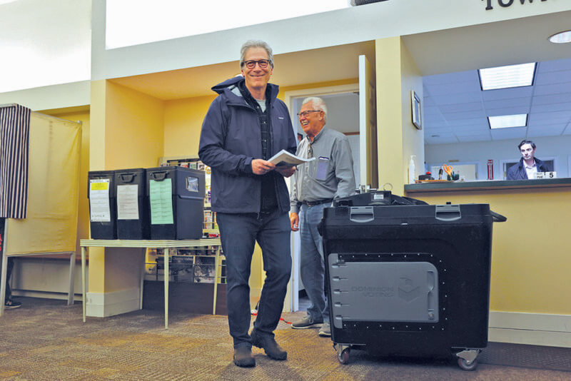 Photo by Catherine Morrissey. Trustee of Public Funds Moe Harvey and Charlotte resident Larry Sommers share a laugh after Larry casts his vote.