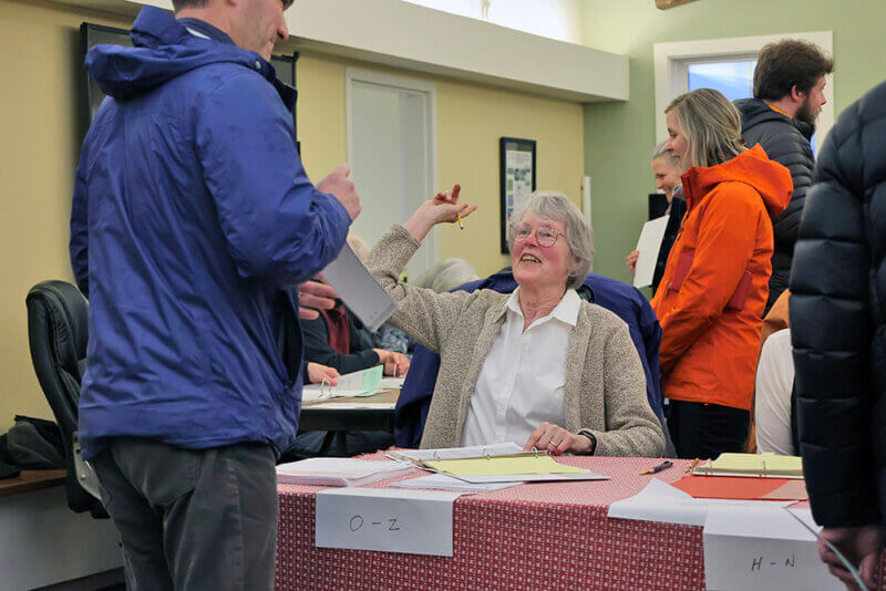 Election day volunteer Kate Mesaros points a Charlotte voter in the right direction on Town Meeting Day.