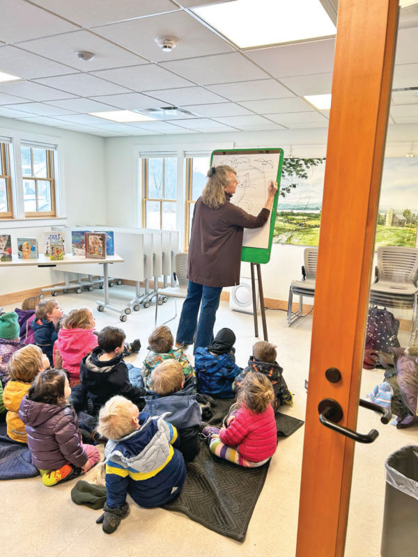 Photo by Margaret Woodruff. Liza Woodruff shares her art at Story Time.