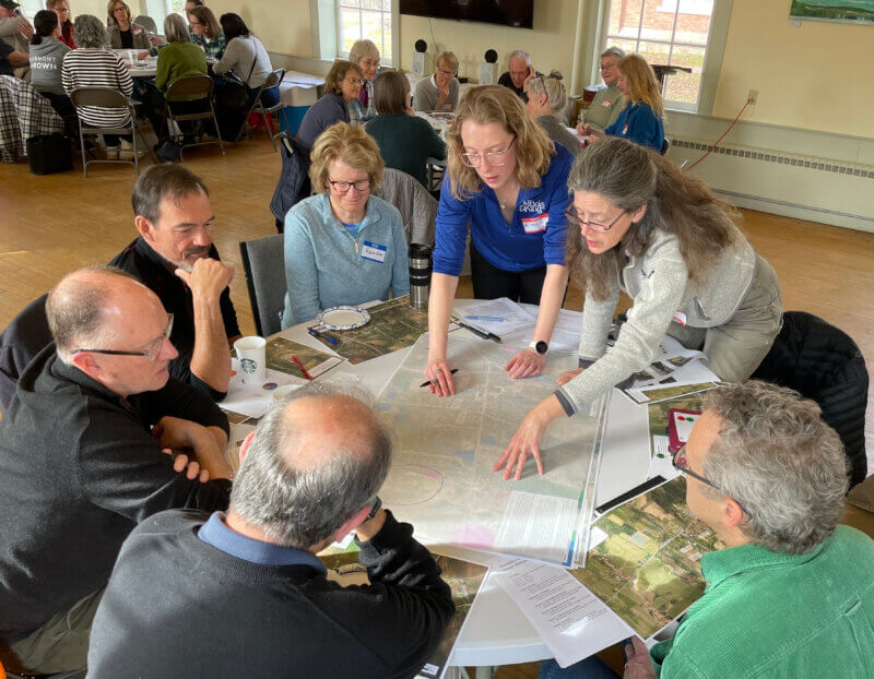 Courtesy photo. One of eight “table groups” at a March 16 design workshop at the Charlotte Congregational Church draw on a tissue paper overlay of the West Charlotte Village map, noting areas that might be appropriate for different kinds of development or parks.