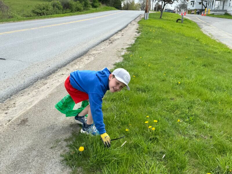 Dex Timmons celebrates Green Up Day, by pitching in to clean up the road in front of his school, Charlotte Central School.