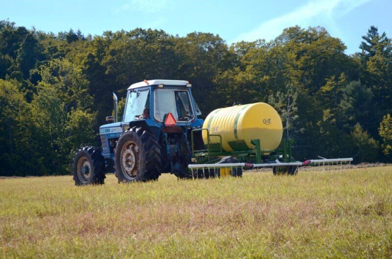 Photo courtesy Rich Earth Institute
A farmer uses a tractor to pull a tank of urine fertilizer over a field. Photo courtesy Rich Earth Institute