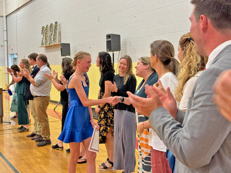Livi Neilson is congratulated by the teachers after receiving her diploma.