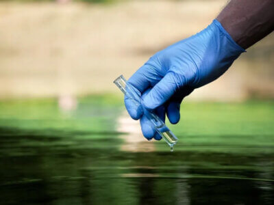 Photo courtesy Saline County, Kansas. Someone collects a water sample.