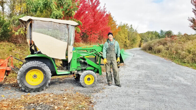 Photo by Jack Pilla. Eric Richardson stands with his tractor after repairs to the Town Link Trail.