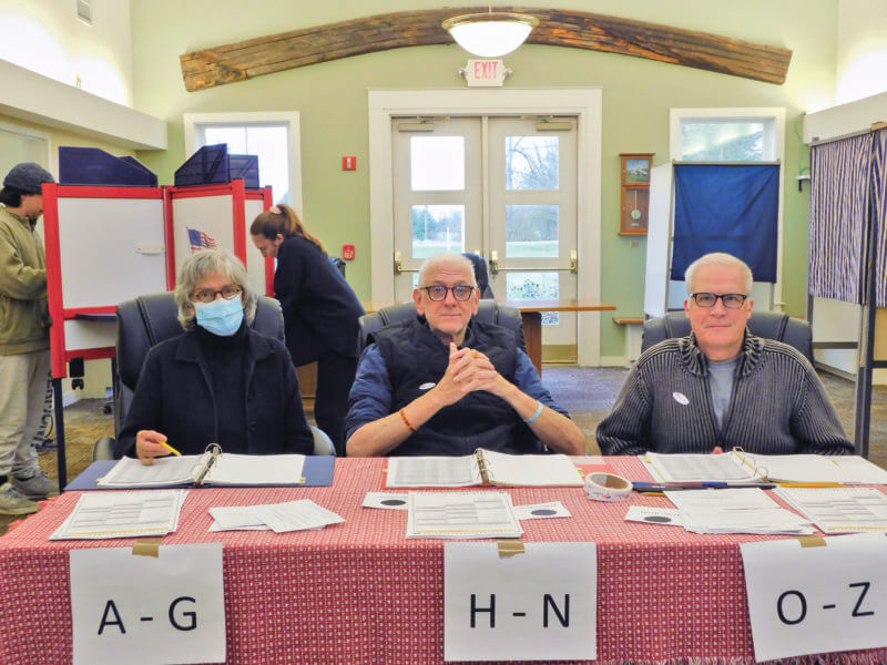 Photo by Julia Streger.
From left, poll workers Elaine Sharrow, Don Goodwin and Matthew Coll were part of the neighborly atmosphere at the Charlotte Town Hall on Election Day.