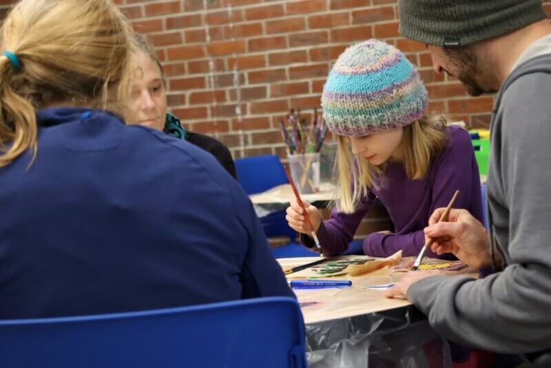 Photo by Catherine Morrissey. Winooski student Lucille works on a leaf that will become part of a larger mural.