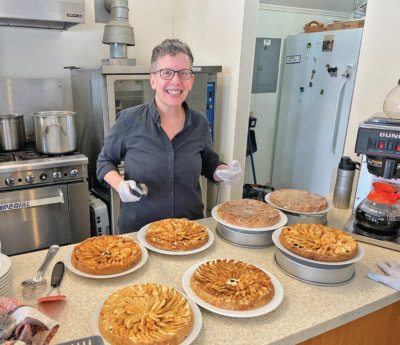 Photo by Lori York. Helen Oetjen serves up apple cheesecake tortes that she baked for Monday Munch.