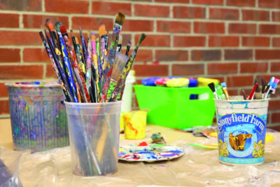 Photo by Catherine Morrissey. Paints and brushes ready to be used at Winooski School District.