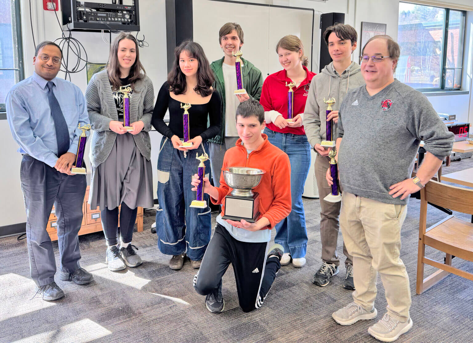 Photo by Kevin Commo. From left, the Champlain Valley Union state championship scholars bowl team is assistant coach Kiran MacCormick, Grace Warrington, Zoe Mui, Charles Redmond, Jacob Graham (kneeling), Leah Rauch, Wylie Ricklefs and coach John Bennett.