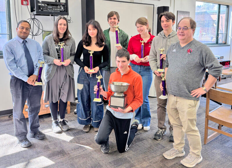 Photo by Kevin Commo.
From left, the Champlain Valley Union state championship scholars bowl team is assistant coach Kiran MacCormick, Grace Warrington, Zoe Mui, Charles Redmond, Jacob Graham (kneeling), Leah Rauch, Wylie Ricklefs and coach John Bennett.