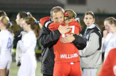 Courtesy photo. Stan Williams hugs his daughter senior Lily Williams after the Redhawks won the state championship game this fall over South Burlington 2-0.
