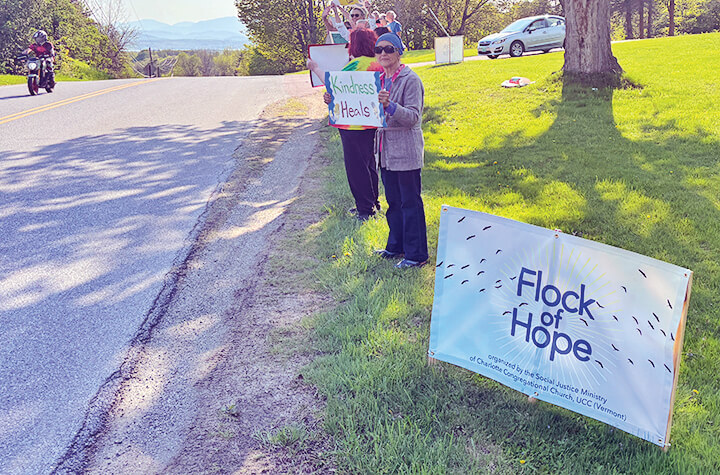 Courtesy photo.
Members of the Charlotte Congregational Church stand in front of the church with signs reflecting their concerns about policy changes coming from Washington.