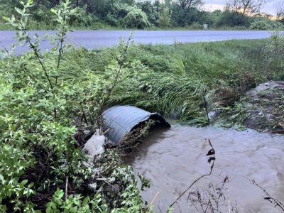 Photo by Scooter MacMillan. Heavy rain on May 17 brought the water out of the culvert and over Greenbush Road just north of the railroad trestle, but it had gone down by the time this photo was taken.