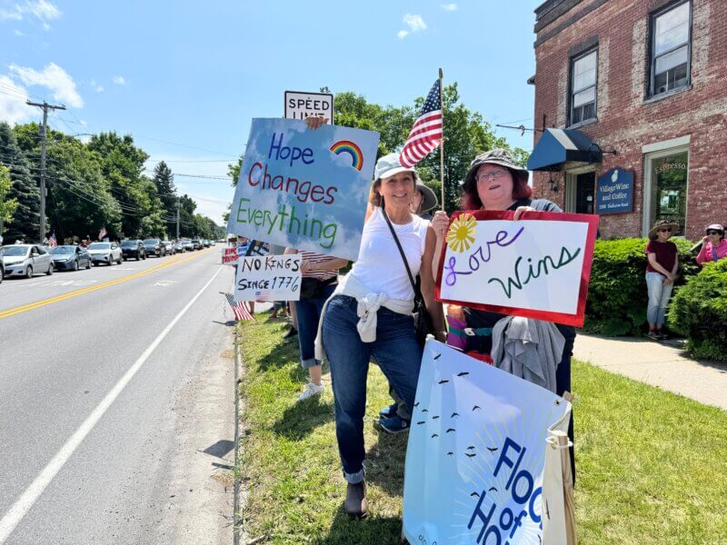 Terri Severance (left) and San Harrington were part of a group from the Charlotte Congregational Church who had banners with more positive messages than many of the other signs.