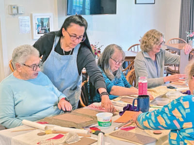 Photo by Lori York. Charlotte resident and local potter Judy Devitt guides participants through the process of creating their own clay slab vases.