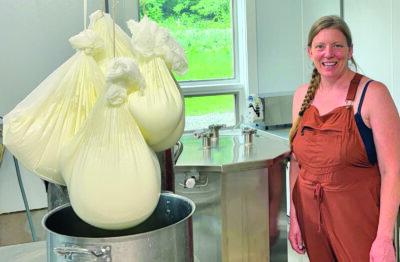 Photo by Elizabeth Bassett. Margaret Aiken stands beside chèvre, or goat cheese, which has to drain its whey for 18 hours.