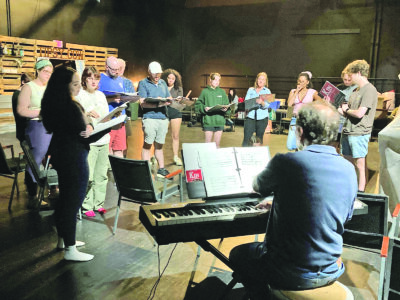 Photo by Mary Recchia. Carl Recchia leads a music rehearsal for “KIN” at the Main Street Landing Blackbox theatre.