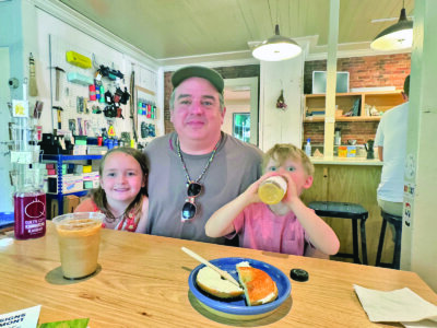 Photo by Scooter MacMillan. From left, Zoë, Shawn and Jasper Dumont discuss their peace-sign quest at the Old Brick Store.