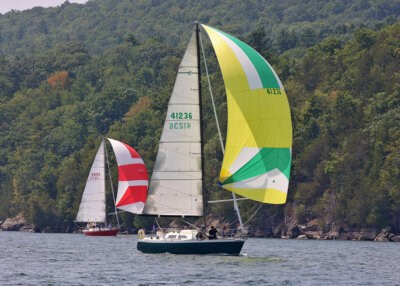 Photos by Lea Ann Smith. From left, Rum Butter, sailed by Ted Castle from Diamond Island Yacht Club, and In Progress, sailed by Malletts Bay Boat Club’s Benedek Erdos, glide along the New York shore under spinnaker during Saturday’s Diamond Island Regatta, with Split Rock Mountain providing the backdrop.
