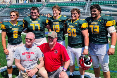 Photo by Calvin Morris. From left, Dylan Frere, Sean Kennedy, Jacob Armstrong, Caleb Scrodin and Joshua Quad represented Champlain Valley Union High as part of the Vermont team battling New Hampshire in the 72nd annual Shrine Maple Sugar Bowl on Aug. 2. In front are CVU coaches Rahn Fleming and John Stempek.