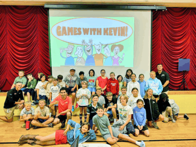 Courtesy photo. The fifth grade, along with game show host and Champlain Valley Union High graduate Kevin Conger, leads Charlotte Central School’s first all-school meeting of the year.