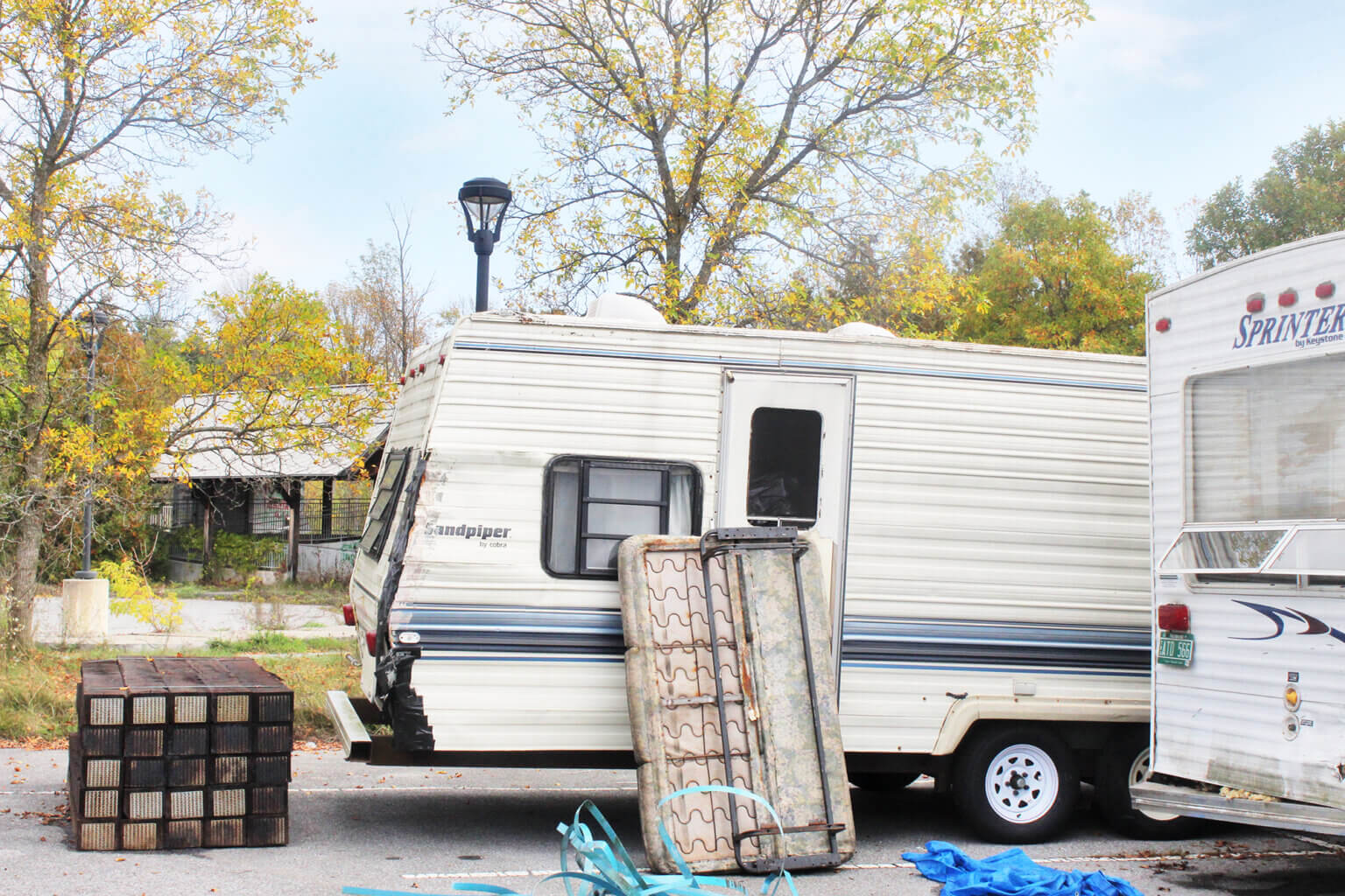 Photo by Scooter MacMillan. A couple of the RVs providing shelter to unhoused people are parked with the train station in the background.
